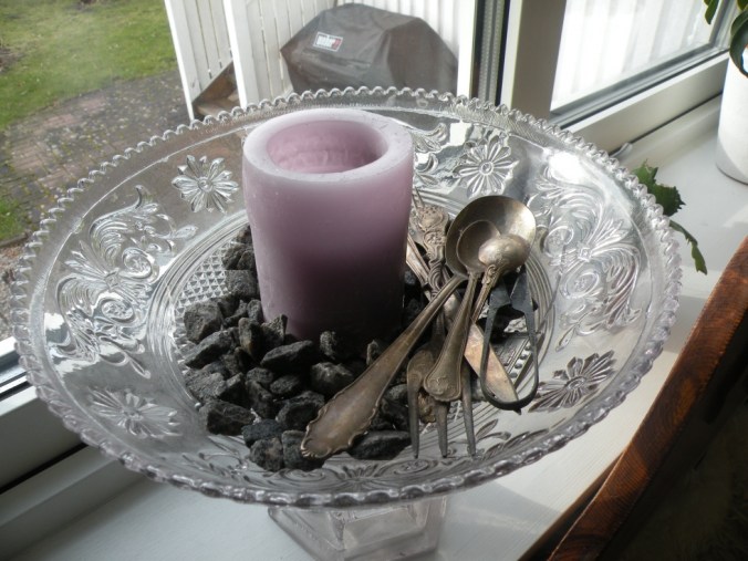 Stilleben med stenar, ljus och gamla bestick i en vacker skål