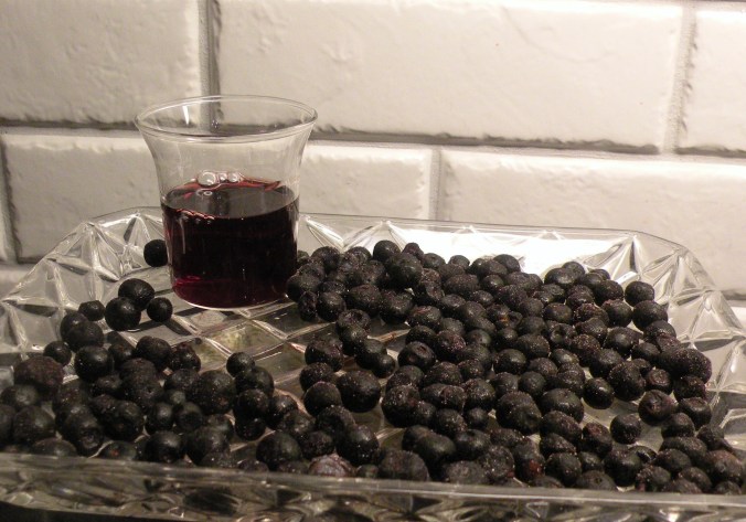 Den färdiga slånbärslikören i sällskap med blåbär.