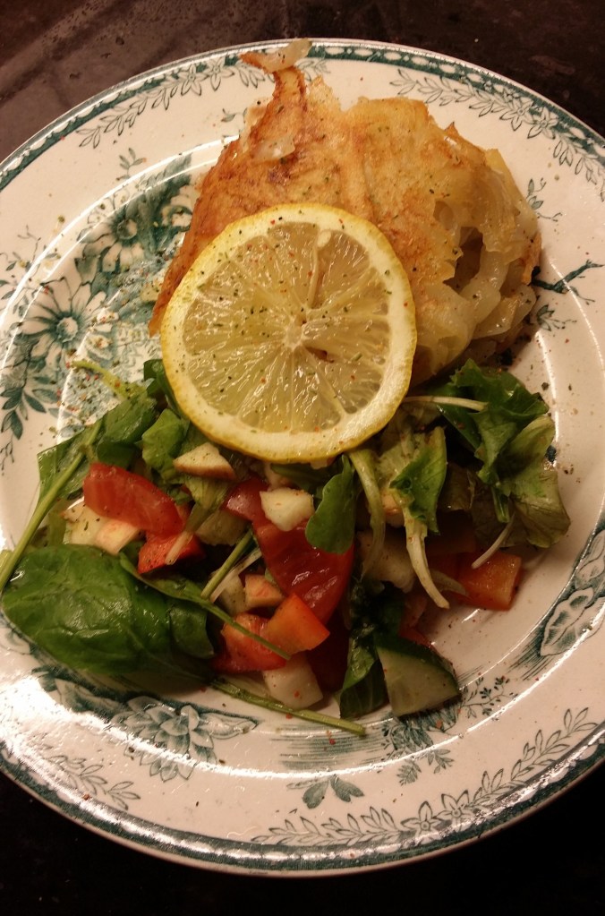 Portion med potatisinbakad fisk och en fräsch sallad.